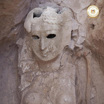 Погребальная маска изображает женщину с улыбкой на лице.